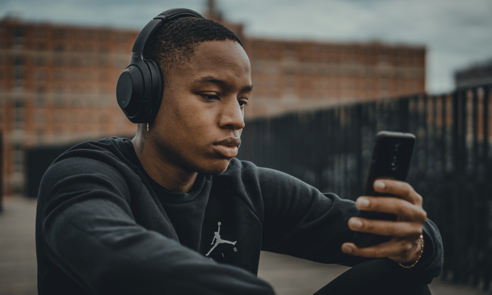 Un homme au casque choisit son écoute sur son téléphone